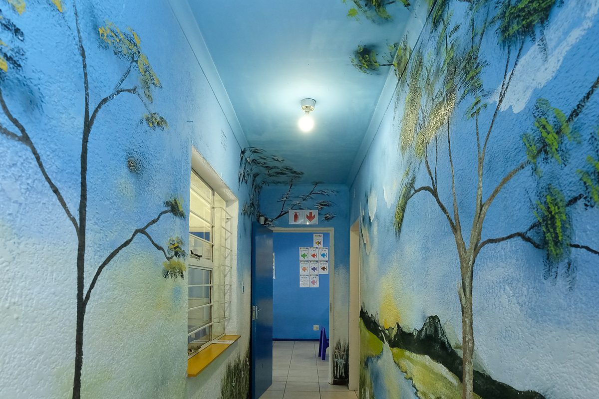 A corridor painted end to end with a blue forest mural