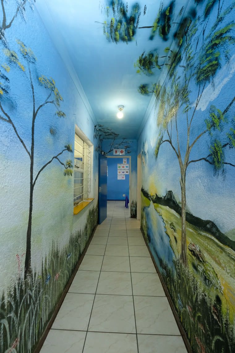 A corridor painted end to end with a forest mural