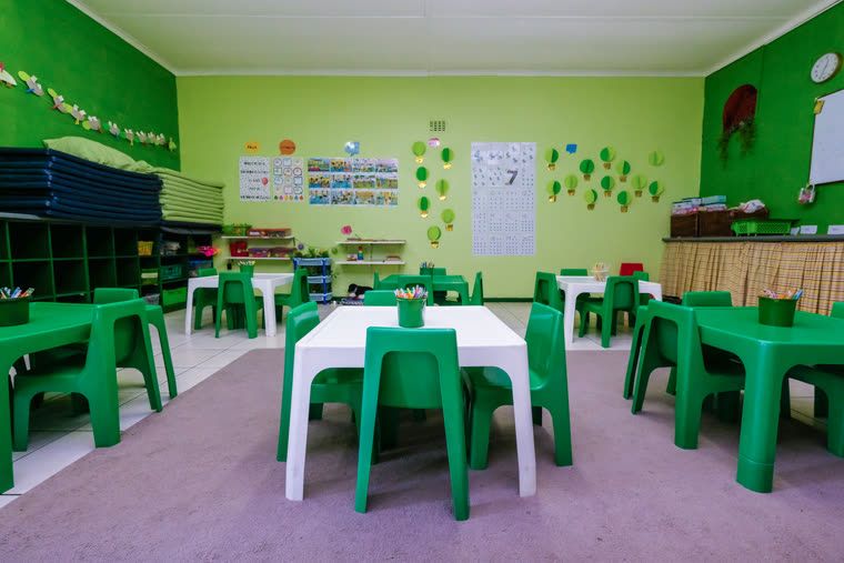 Green Class: green walls with matching tables and chairs, and storage along the wall